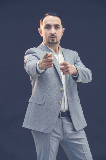 istock Handsome young man pointing at you, isolated over black background. 1222251151