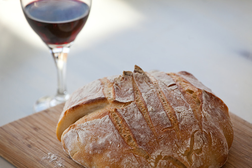 A loaf of bread and red wine for communion. Christian or religious theme.