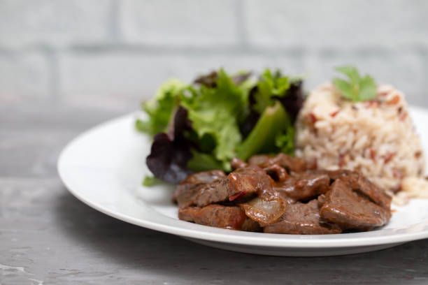istock fried liver with salad and boiled rice on white plate 1222252329