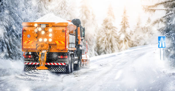 manutenzione autostradale salata. camion spazzaneve su strada innevata in azione. - aratro foto e immagini stock