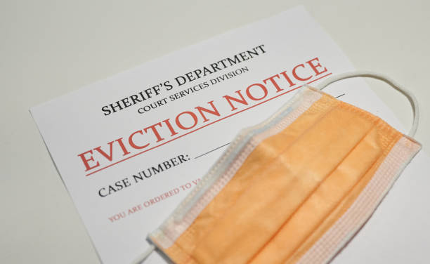 Yellow facial mask laying on top of the eviction note from sheriff's department stock photo