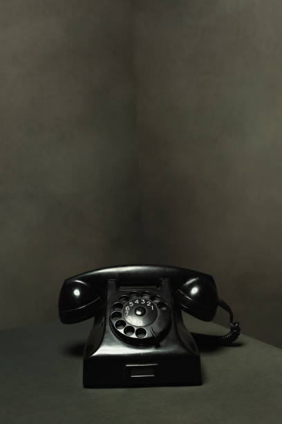 istock Vintage black telephone in gray empty room. 1222255588