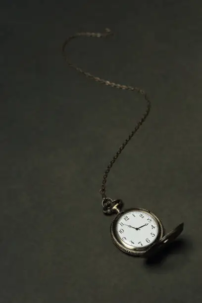 Photo of Antique victorian pocket watch on grey surface.