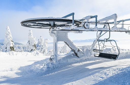 End of ski lifts high in frozen mountains. Winter empty lift seats in winter holiday.