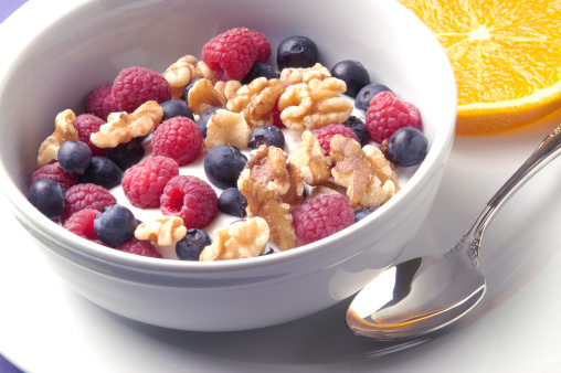 Close up of a bowl of Greek Yogurt with blueberries, raspberries and walnuts.