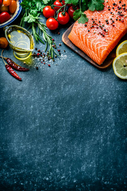 istock Raw salmon fillet border on dark background. Copy space 1222257027