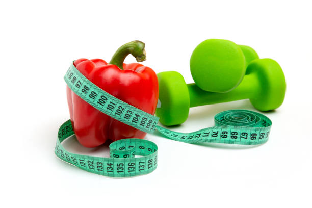 istock bright red peppers and green cucumbers with Measuring tape white background 1222257086