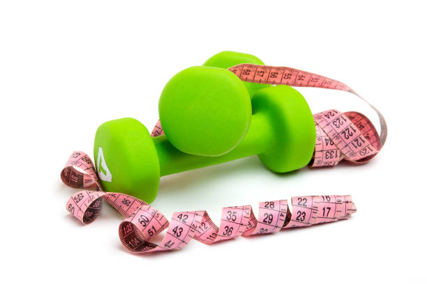 istock green dumbbells with a Measuring tape on a white background 1222257097