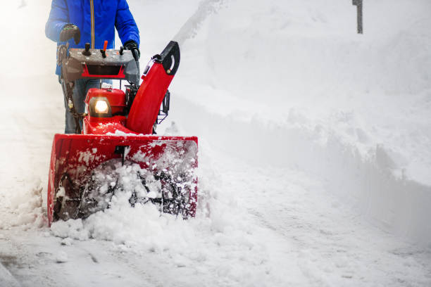 Man clearing or removing snow with a snowblower Man clearing or removing snow with a snowblower on a snowy road detail. snow plow stock pictures, royalty-free photos & images