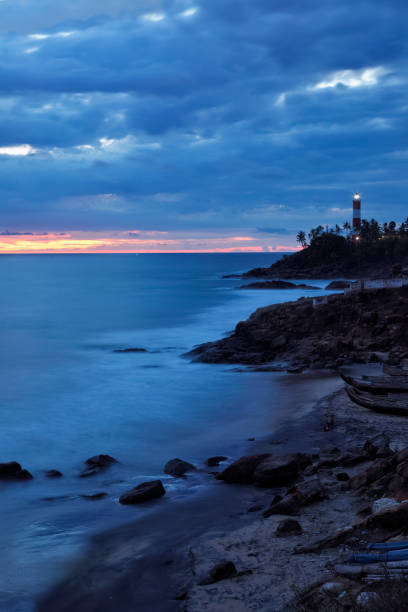 маяк ковалам вижинджам на закате. керала, индия - storm lighthouse cloudscape sea стоковые фото и изображения