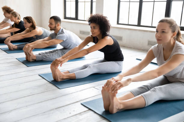 istock Diverse people during yoga session doing Seated Forward Bend asana 1222262954
