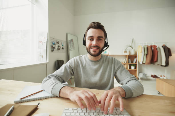 istock Friendly young bearded customer support representative pressing keys of keypad 1222263312