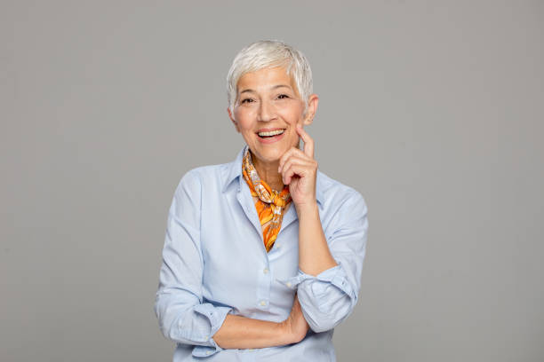 istock Happy senior woman against grey background. 1222263993