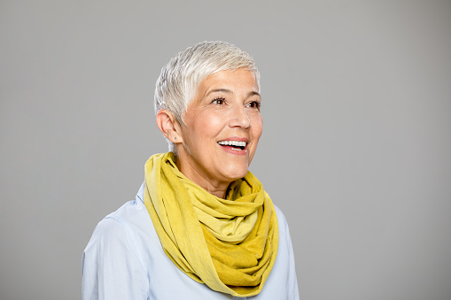Portrait of beautiful mature business woman in casual clothes isolated over grey background. Attractive middle aged woman with beautiful smile.