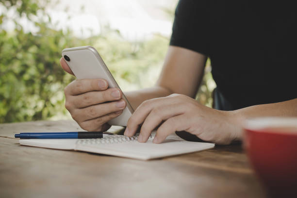 istock young man relaxed working with digital mobile smart phone and report document with red coffee cup on desk at cafe restaurant, work from home, digital technology, internet, business financial concept 1222264714