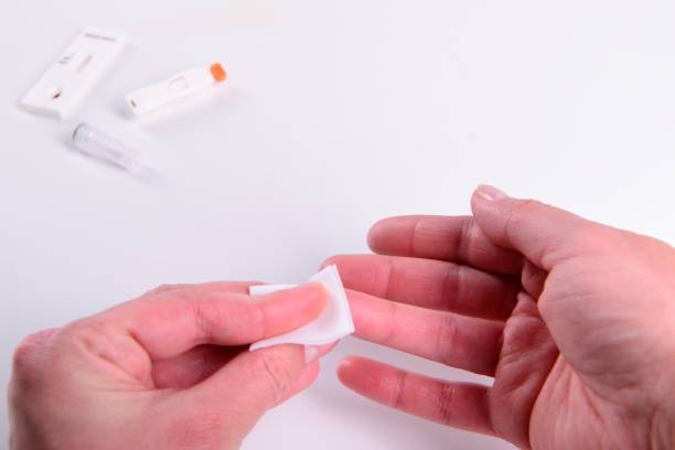 blood test woman taking blood sample using sterile alcohol wipe on finger closeup isolated on white - medical sample imagens e fotografias de stock