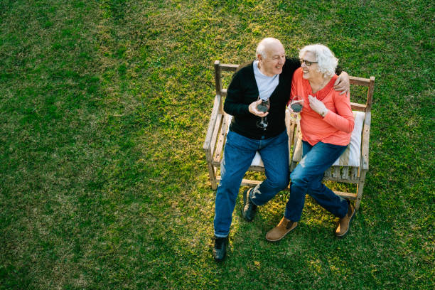 coppia anziana che si gode il giardino - couple affectionate relaxation high angle view foto e immagini stock