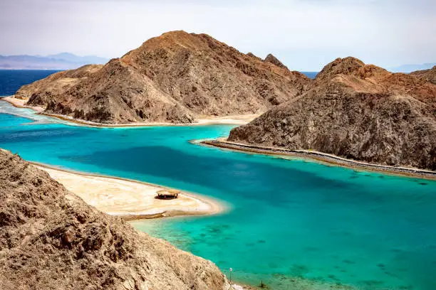 Beautiful Panoramic view of the Fjord Bay Taba in Aqaba Gulf, Egypt. Turquoise clear water of Red Sea and rocky mountains around.