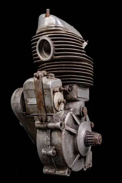 Old slightly dirty motor speedway motorcycle. Single-cylinder engine powered by ethanol. Dark background.