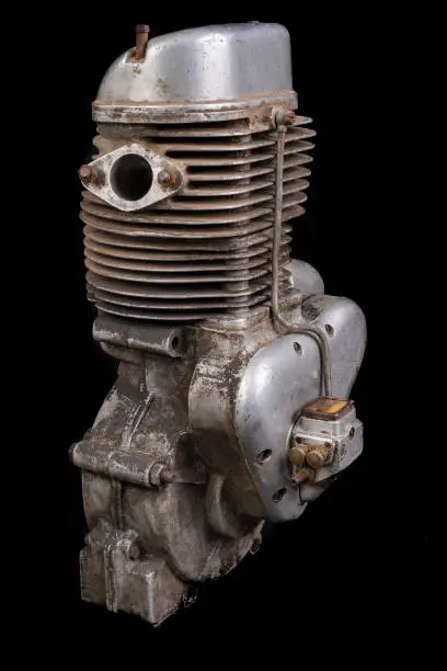 Old slightly dirty motor speedway motorcycle. Single-cylinder engine powered by ethanol. Dark background.