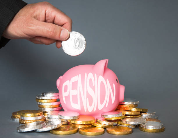 un concepto de pensiones y ahorros con un empleado o empleador que contribuye a un fondo de pensiones colocando monedas en una alcancía - performance perks incentive coin fotografías e imágenes de stock