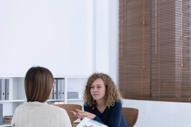 istock Professional counselor and woman suffering from depression during therapy 1222276340