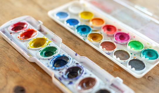 Colorful watercolor palette on wood table.