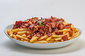 Portion of french fries with sliced bacon
