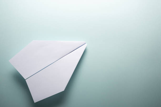 istock White paper airplane on a turquoise background 1222278804