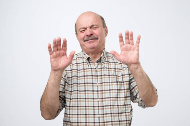 Hispanic mature man showing refusal gesture. It is not for me, leave me in piece