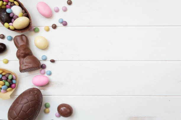 コピースペース付き白い木製テーブルの上のチョコレートイースターキャンディーのトップビュー - chocolate chocolate candy dark chocolate directly above ストックフォトと画像