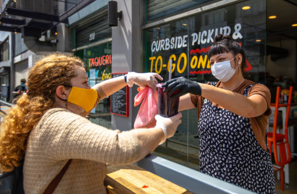 istock Masked Restaurant Worker and Customer Outside Restaurant During Covid-19 Lockdown 1222296682