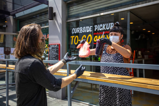 istock Man Wearing Bandana Over Face Picking Up Order at Restaurant During Covid-19 Lockdown 1222296684