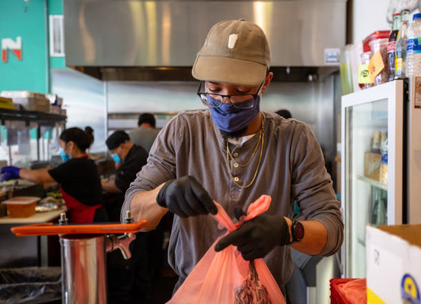 istock Masked Restaurant Employee Bagging Up To-Go Order During Covid-19 Lockdown 1222296716