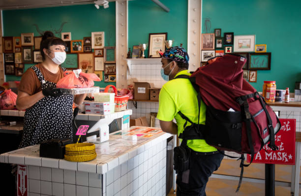 istock Delivery Worker Arriving in Restaurant to Pick Up Order During Covid-19 Lockdown 1222296727