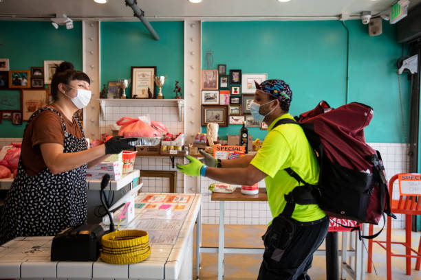 istock Delivery Cyclist Collecting Order from Restaurant During Covid-19 Lockdown 1222296751