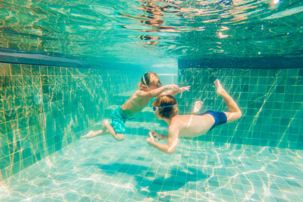 istock two children diving in masks underwater in pool 1222302276