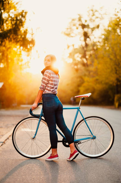 istock Happy Girl with a Bicycle in sunset 1222304612