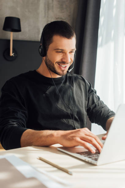 istock selective focus of happy operator in headset using laptop at home 1222308461