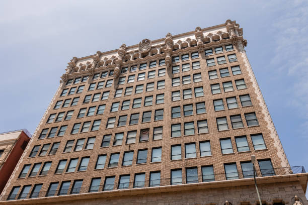 View of rooftops of downtown Tulsa Oklahoma -mixture of Art Deco and modern buildings with an American flag against very clear blue sky