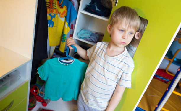 istock Seven year old boy disassembles his clothes. Stays at home during the coronavirus pandemic. 1222310405