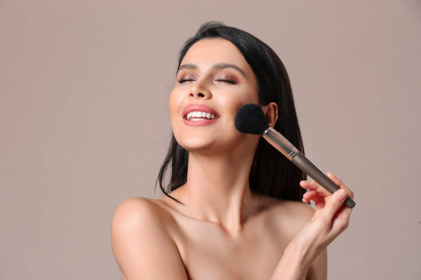 beautiful young woman applying foundation powder - brushing women make up ceremonial makeup imagens e fotografias de stock