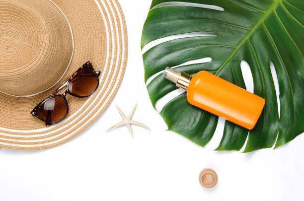 istock Summer straw hat, tropical monstera leaf, sunglasses, shells, suncream, starfish on red background. 1222310766