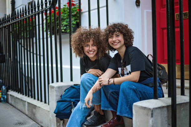 istock Beautiful curly haired sisters sitting on the staircase 1222312426