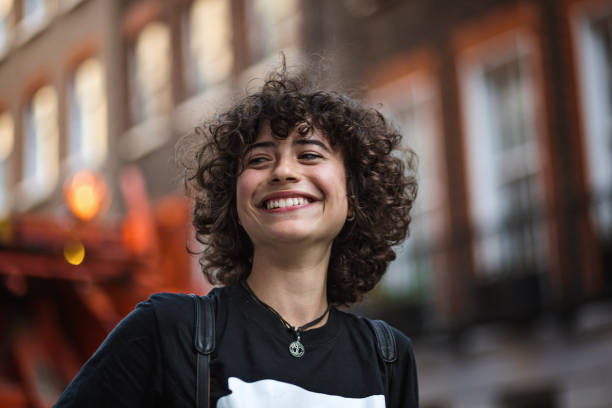 istock Cheerful and carefree curly haired female student 1222312536