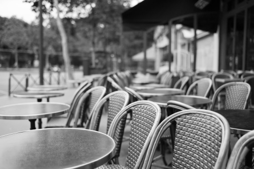 Row of chairs and coffee tables in an empty street cafe in Paris, France