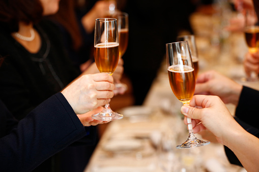 female participants toasting champagne glasses at an indoor party venue