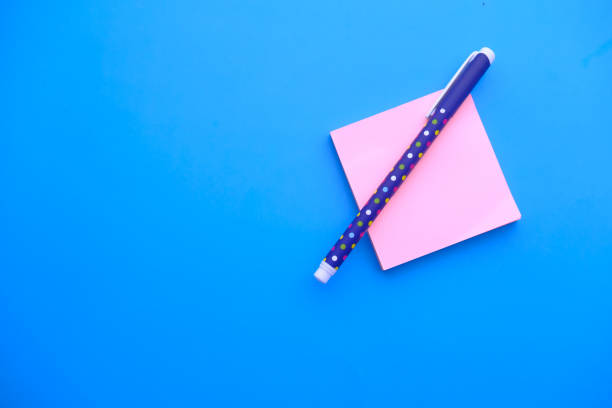 istock high angle view of notepad and pen on blue background 1222333259