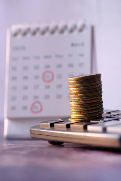 istock Close up of stack of coins on calculator 1222333412