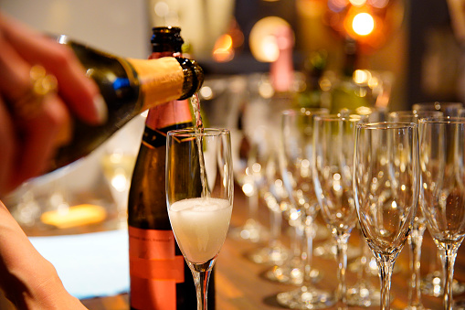Sparkling wine poured into a glass at a party venue